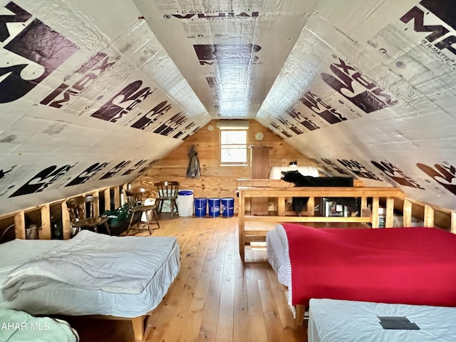 bedroom with lofted ceiling and wood-type flooring