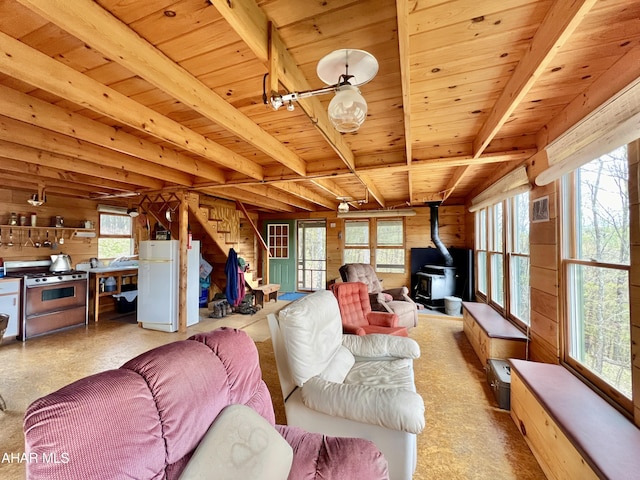 living room with wood walls, a wood stove, beam ceiling, and wooden ceiling