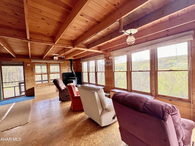 living room with wood walls, a wood stove, hardwood / wood-style flooring, vaulted ceiling with beams, and wood ceiling