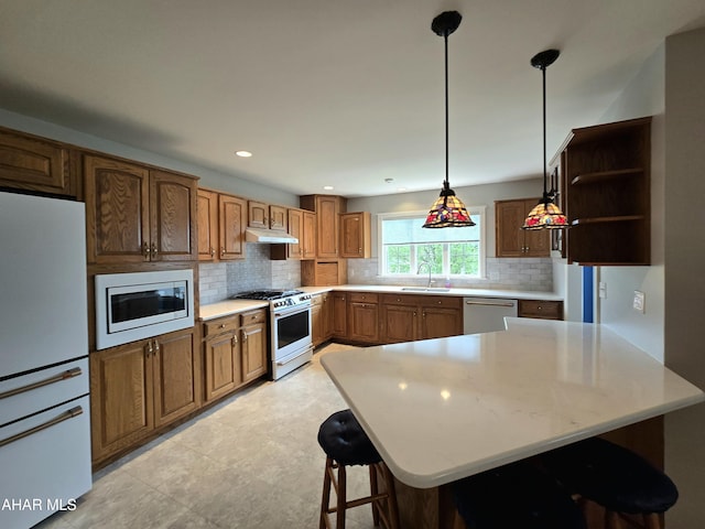 216 Red Fox Dr, Duncansville, PA 16635 - kitchen with stainless steel appliances, under cabinet range hood, a sink, backsplash, and a kitchen bar
