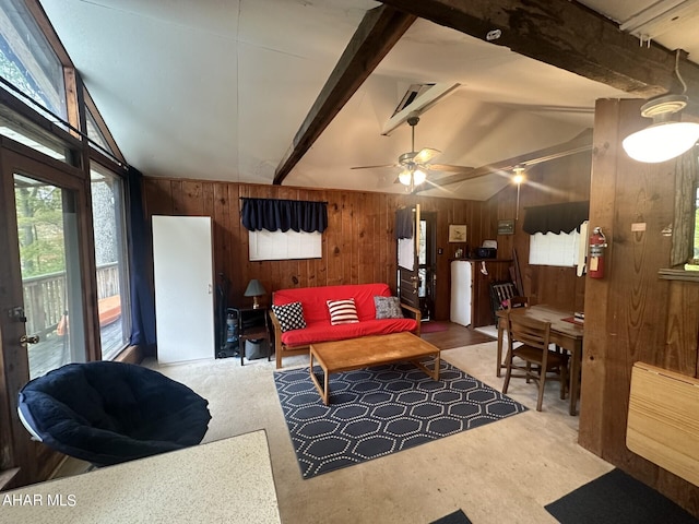 living room with wood walls, plenty of natural light, ceiling fan, and lofted ceiling with beams