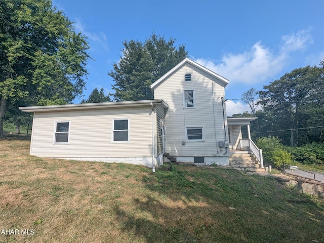 back of house with a lawn