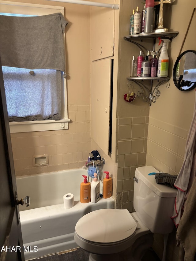 bathroom featuring toilet and tile walls