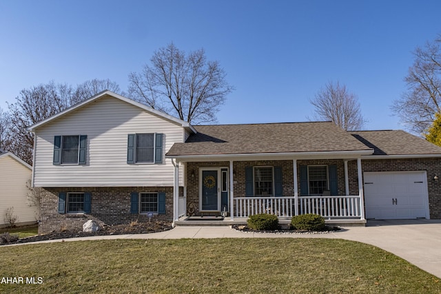 tri-level home featuring an attached garage, covered porch, a front lawn, concrete driveway, and brick siding