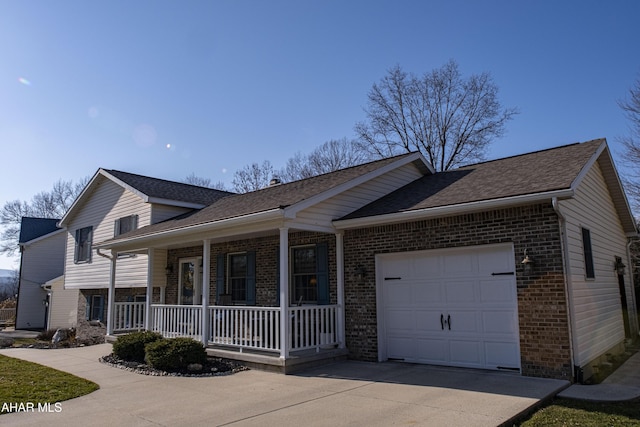 tri-level home with driveway, covered porch, a shingled roof, a garage, and brick siding