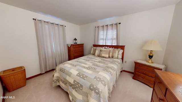 bedroom featuring baseboards and light colored carpet