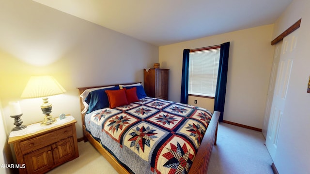 bedroom featuring light colored carpet and baseboards