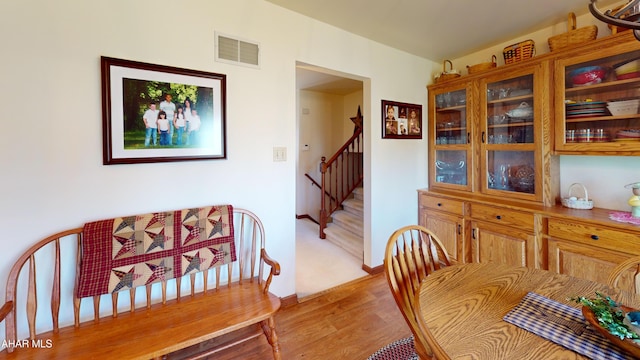 dining room with visible vents, baseboards, light wood-style floors, and stairs