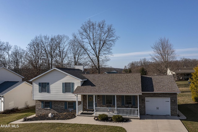 tri-level home with a shingled roof, a front lawn, a porch, concrete driveway, and a garage