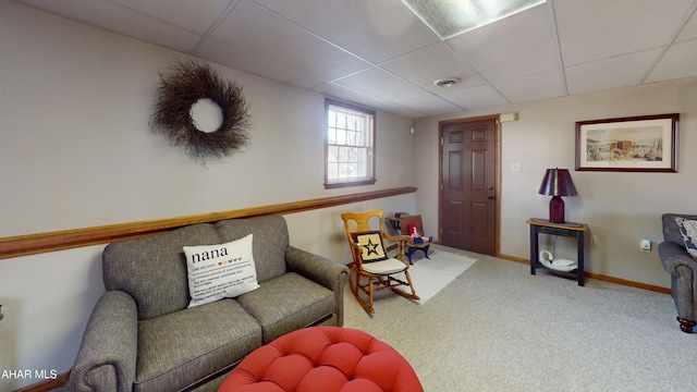 carpeted living room featuring a paneled ceiling and baseboards