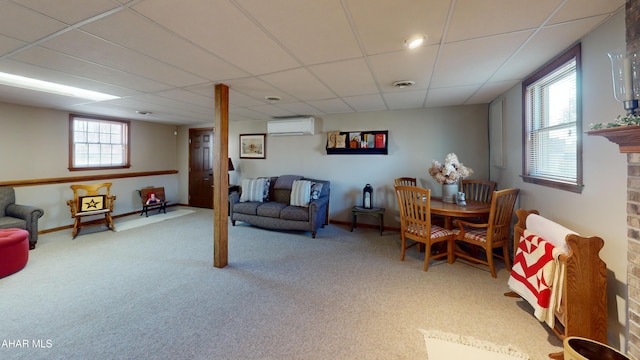 interior space with visible vents, baseboards, a paneled ceiling, carpet flooring, and a wall mounted AC