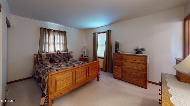 bedroom with light carpet and baseboards