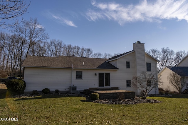 back of property featuring a patio area, a lawn, a chimney, and roof with shingles