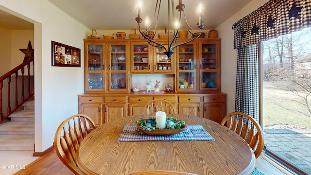 dining area featuring an inviting chandelier, stairway, and baseboards