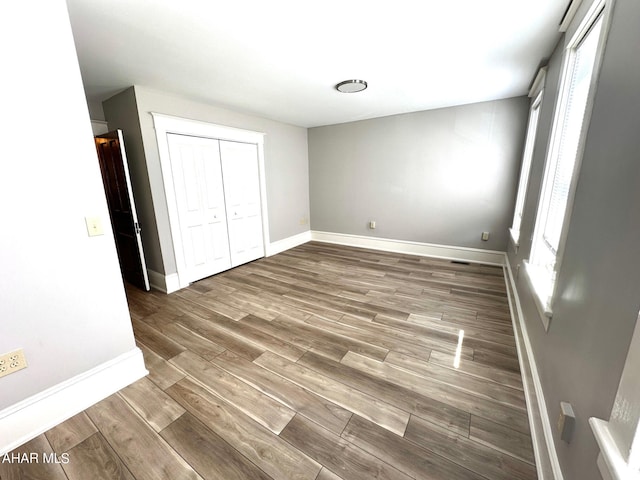 unfurnished bedroom featuring hardwood / wood-style flooring and a closet