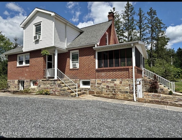 view of front of home featuring a sunroom and cooling unit