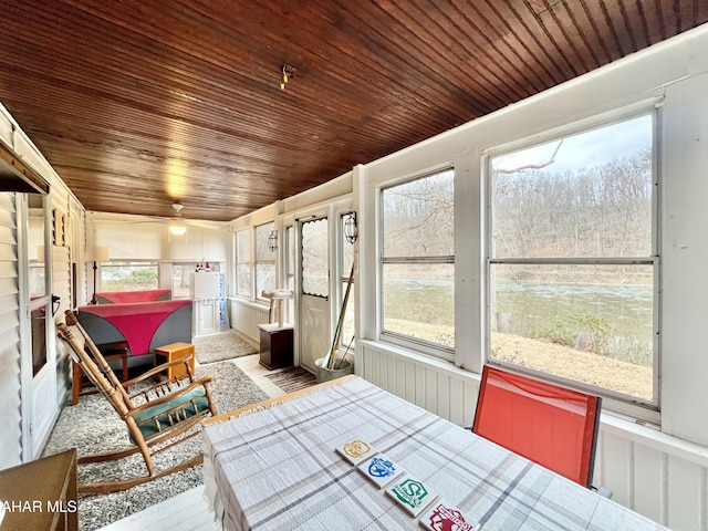 sunroom with ceiling fan and wooden ceiling