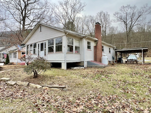 back of house with a carport and a sunroom