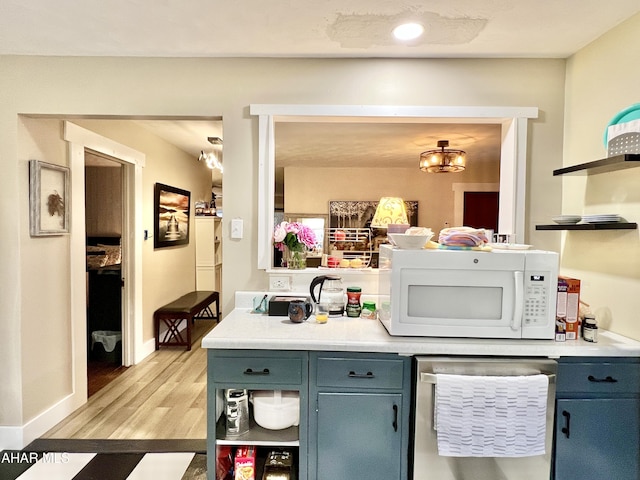 interior space with dishwasher, blue cabinets, and light hardwood / wood-style flooring