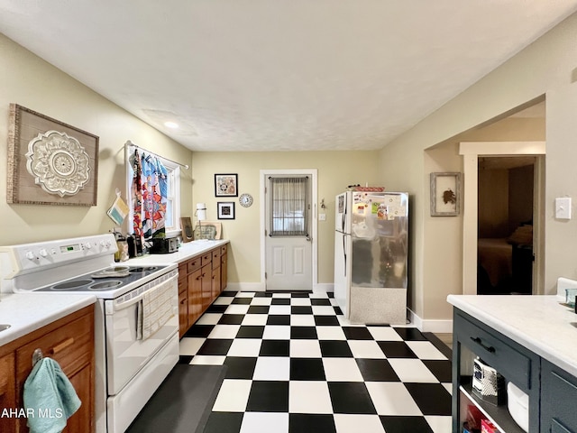 kitchen featuring white electric range oven and stainless steel fridge