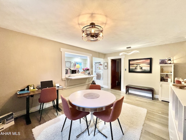 dining room with a chandelier and light hardwood / wood-style floors