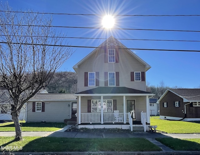 view of front of house with a front yard and a porch