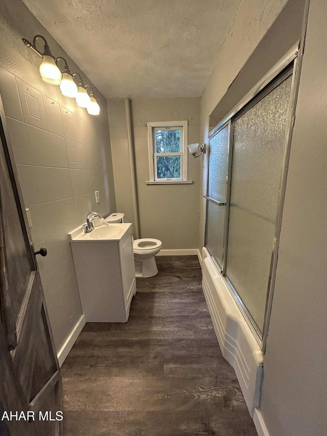 325 Mcfarland Rd, Tyrone, PA 16686 - bathroom featuring a textured ceiling, vanity, wood finished floors, and shower / bath combination with glass door