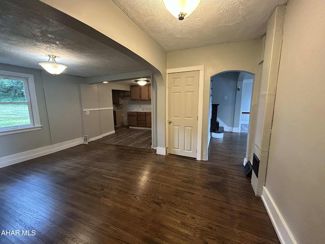 325 Mcfarland Rd, Tyrone, PA 16686 - unfurnished living room featuring arched walkways, a textured ceiling, and wood finished floors