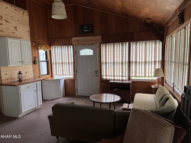 living room featuring lofted ceiling, wooden walls, and light carpet