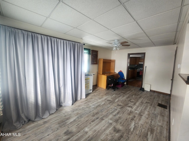 interior space featuring a paneled ceiling, hardwood / wood-style floors, and ceiling fan