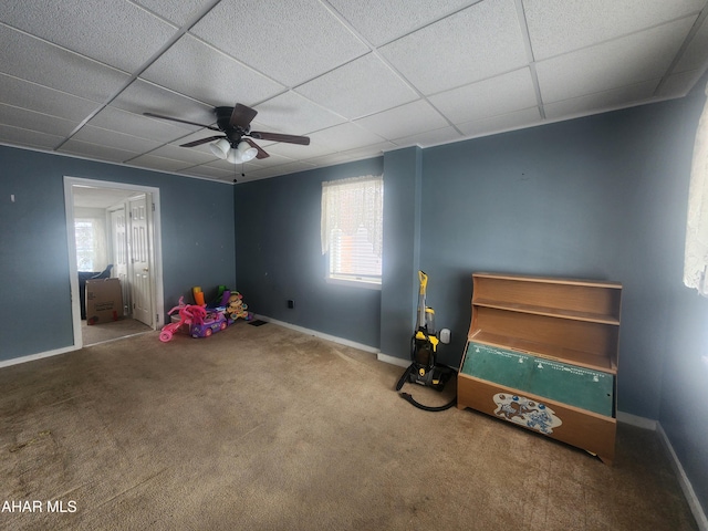 recreation room featuring ceiling fan, carpet, and a drop ceiling