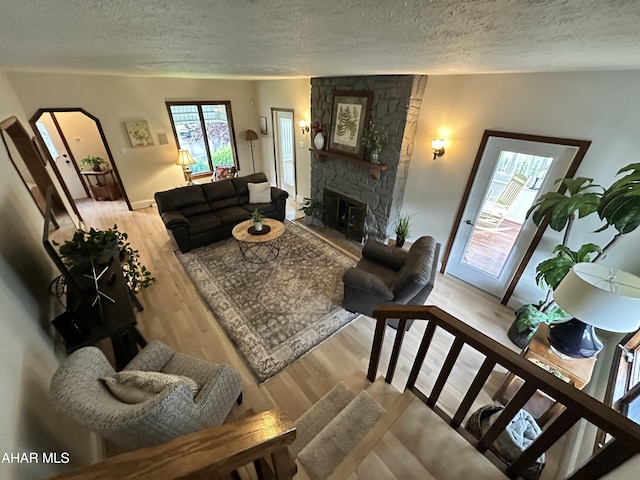 705 Clark St, Hollidaysburg, PA 16648 - living room featuring a textured ceiling, wood finished floors, arched walkways, and a fireplace