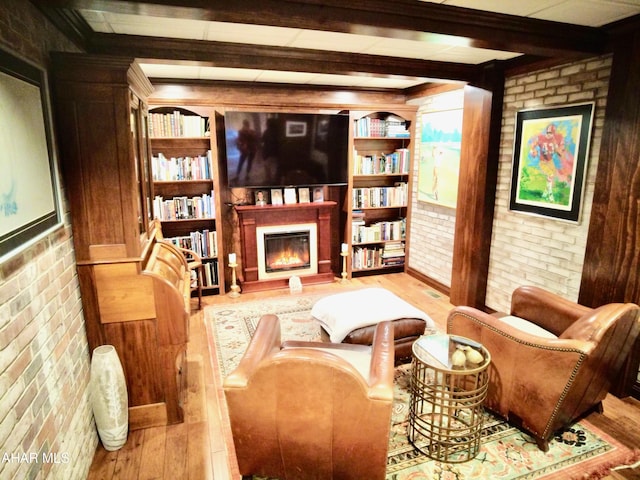 9510 Lincoln Hwy, Bedford, PA 15522 - sitting room with wood finished floors, brick wall, beamed ceiling, and a warm lit fireplace