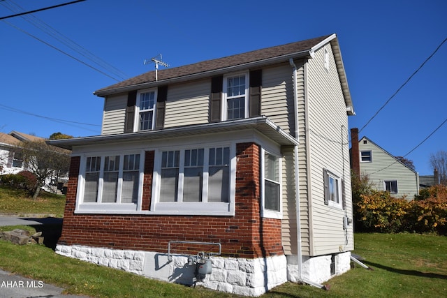 view of side of home with a lawn and a sunroom