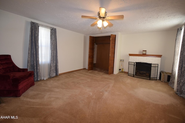 unfurnished living room with ceiling fan, a fireplace, light colored carpet, and a textured ceiling