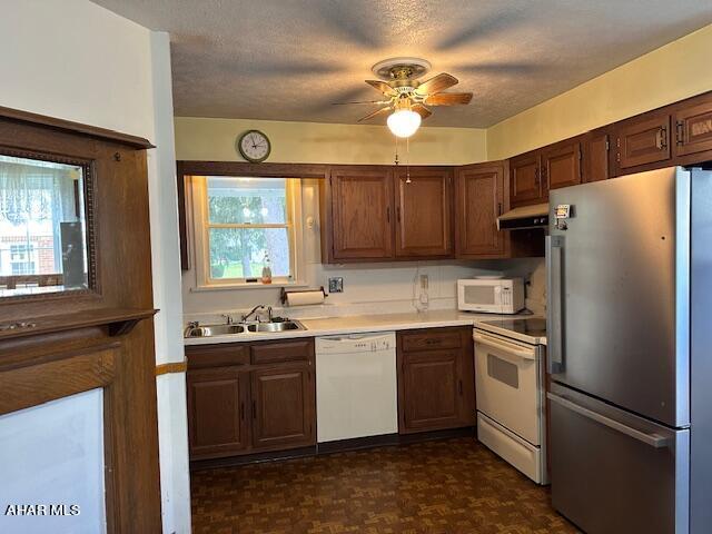 kitchen featuring ceiling fan, sink, ventilation hood, a textured ceiling, and white appliances