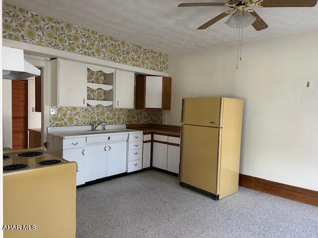 kitchen featuring white cabinets, ceiling fan, white appliances, and a textured ceiling