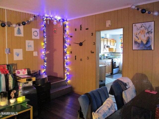 interior space with crown molding, wooden walls, and wood finished floors