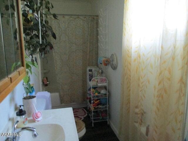 bathroom with a sink, toilet, and shower / bath combination