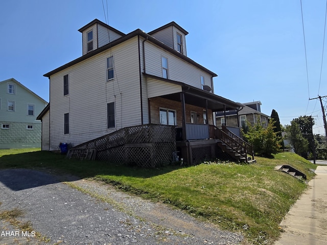 view of home's exterior featuring covered porch and a yard