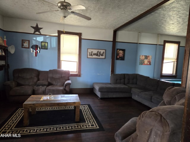 living room with a textured ceiling, dark hardwood / wood-style floors, a wealth of natural light, and ceiling fan