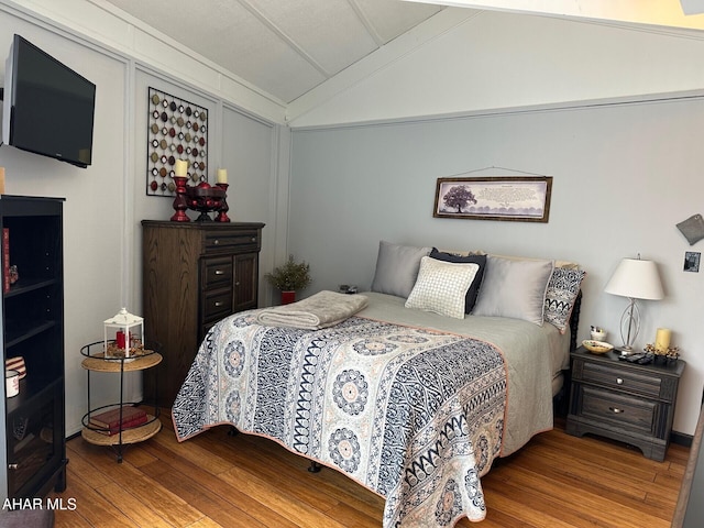 bedroom with light hardwood / wood-style floors, crown molding, and vaulted ceiling