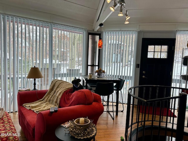 sunroom featuring vaulted ceiling with beams