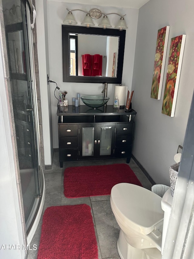 bathroom with tile patterned floors, toilet, a shower with door, and vanity