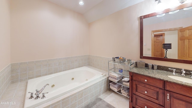 bathroom featuring a tub with jets, vanity, and tile patterned floors