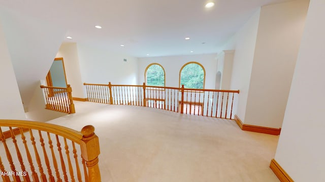 hallway with carpet flooring, an upstairs landing, baseboards, and recessed lighting