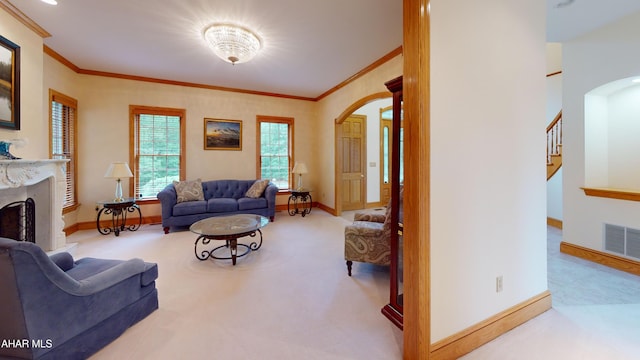 living room featuring arched walkways, ornamental molding, baseboards, a fireplace with raised hearth, and carpet