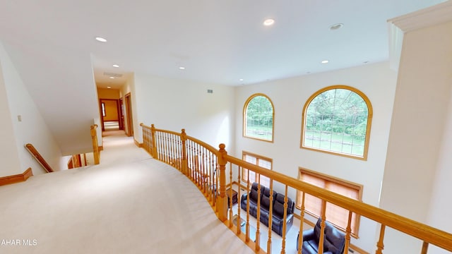 corridor featuring an upstairs landing, recessed lighting, and light carpet