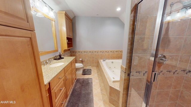 bathroom featuring a stall shower, tile patterned flooring, a whirlpool tub, vanity, and toilet