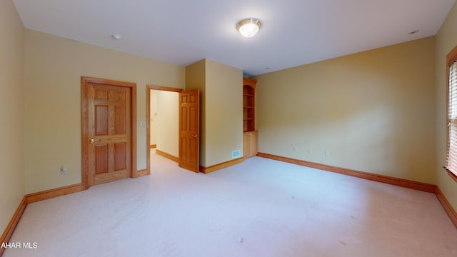 empty room featuring baseboards, light carpet, and a smoke detector